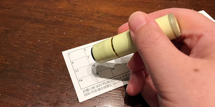 紙のスタンプカードへハンコを押す様子